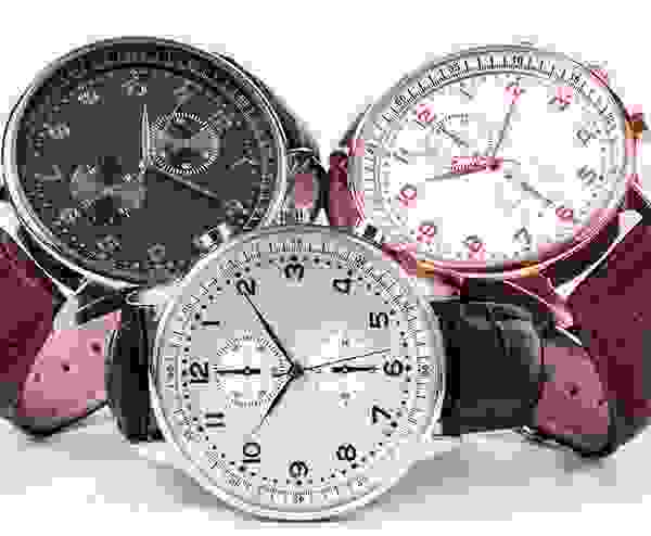 Three watches are shown in a row, one of which has pink numbers.