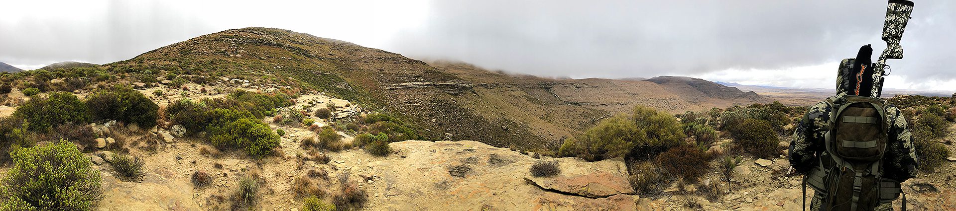 A view of the top of a mountain with fog rolling in.