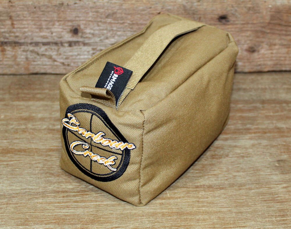 A tan bag sitting on top of a wooden table.