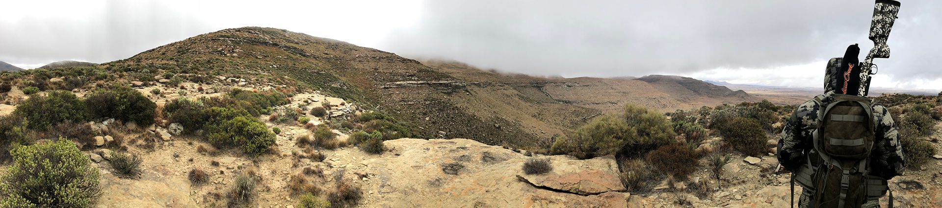 A view of the top of a mountain with fog rolling in.